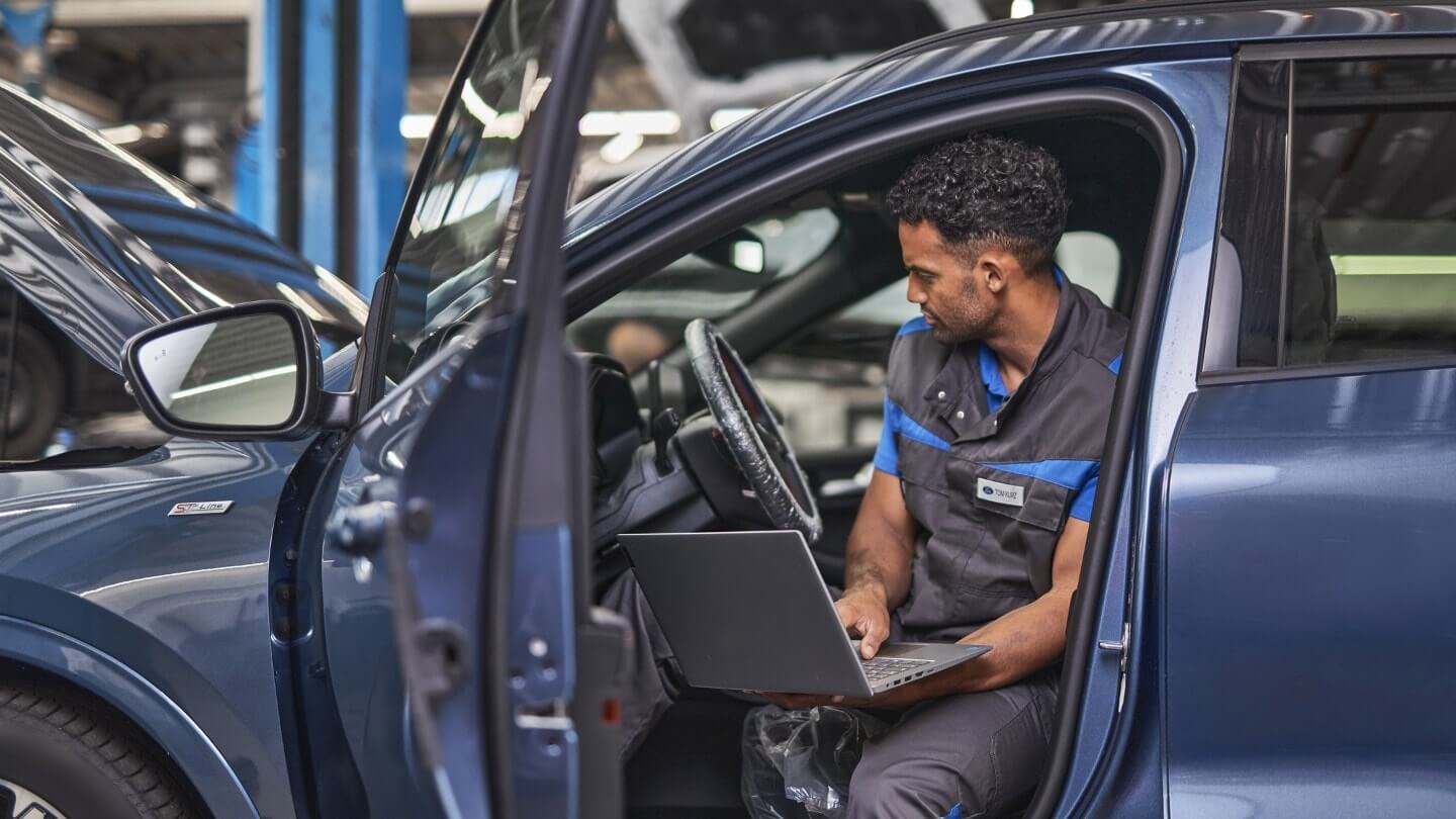 Homme inspecte véhicule bleu